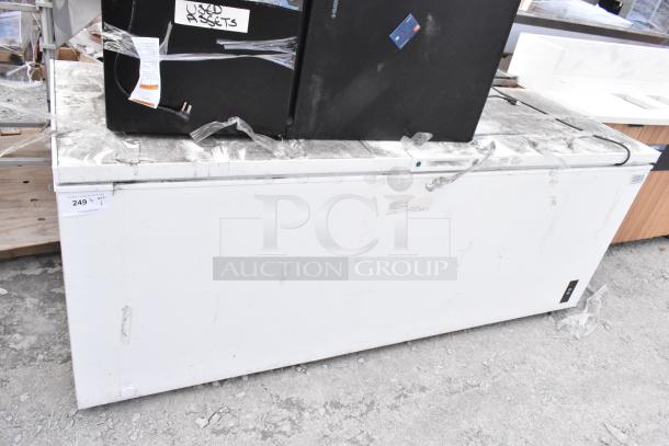 Frigidaire FFCL2542AW chest freezer, 115 Volts, signs of wear, auction tag showing $249, "USED ASSETS" label visible.