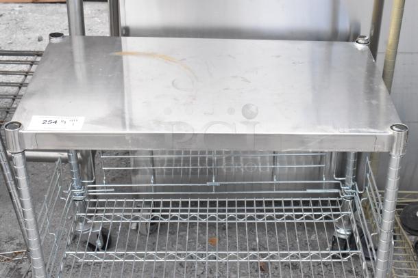 Chrome finish 2-tier wire shelving unit on commercial casters. Good condition, buyer must dismantle; freight charges apply.