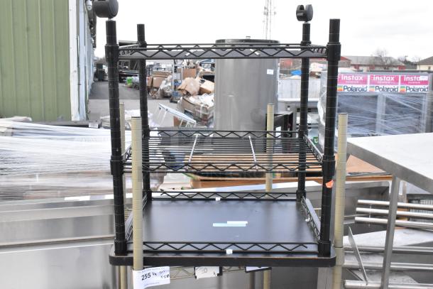 Two-tier wire shelving units with commercial casters, one missing casters. Includes auction tags. Buyer must dismantle.