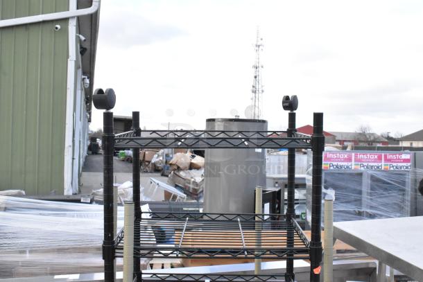 Two-tier wire shelving unit on casters, one missing casters. Requires dismantling for shipping. Suitable for commercial use.