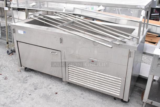 Stainless steel commercial buffet station with storage, equipped with commercial casters for mobility, in used condition.
