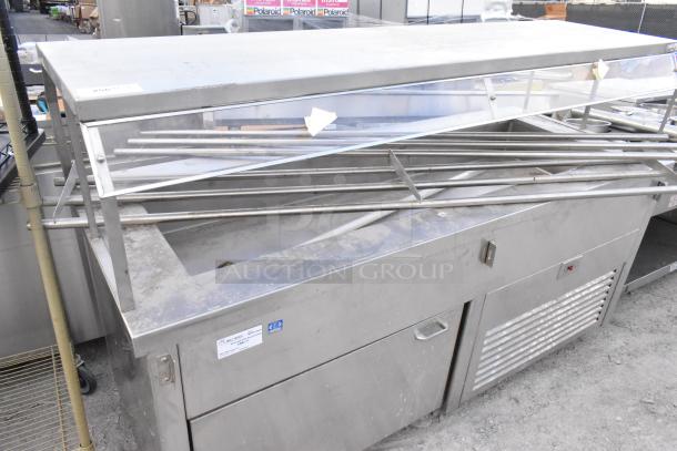 Stainless steel commercial buffet station with glass guard and storage, on casters. Features a spacious top and durable construction.