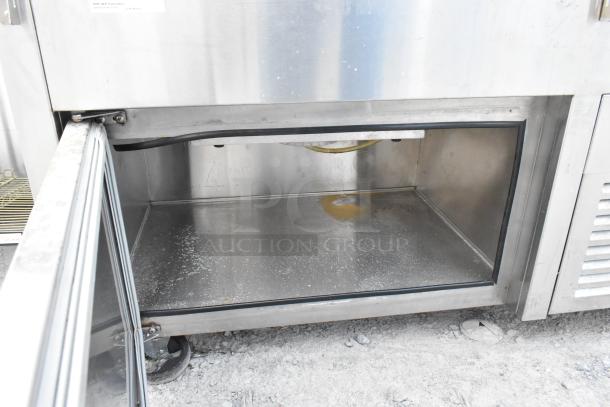 Stainless steel commercial buffet station on casters, open compartment shown, visible wear and rust spots, ideal for catering.