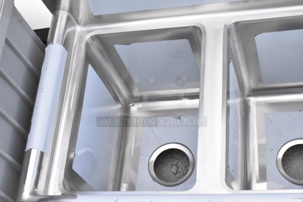 Brand new Regency 58" stainless steel three-compartment sink with visible dents, no legs, galvanized steel construction, includes 2 drainboards.