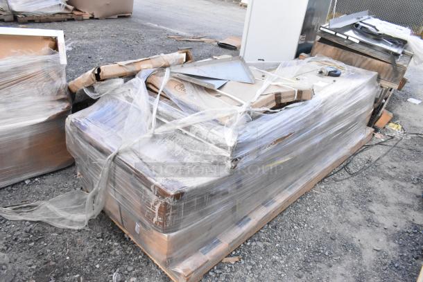 Six brand new scratch and dent Regency stainless steel commercial work tables, wrapped on a pallet, ready for auction.