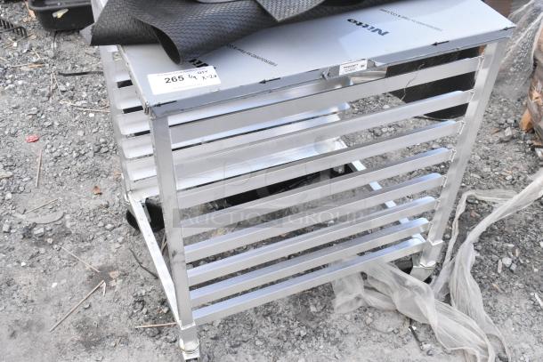 Brand new Regency metal commercial pan transport rack with visible scratches, and a textured floor mat on top.