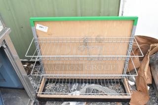 Gray 3 tier shelving unit with wire shelves and a chain, leaning against wooden and metal frames. Item tag marked "269".