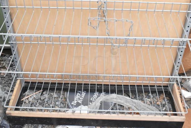 Gray 3 tier shelving unit, metal frame, good condition, wire shelves, suitable for storage, visible chain attachment.