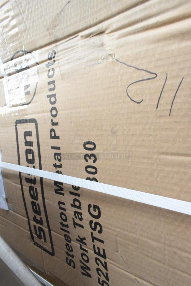 Cardboard box labeled "Steelton 522ETSG3030 Work Table." Box appears new with some dents.