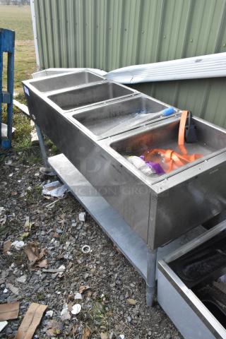 Eagle Stainless Steel 4 Bay Steam Table with metal under shelf, weathered condition, includes visible bins and straps.