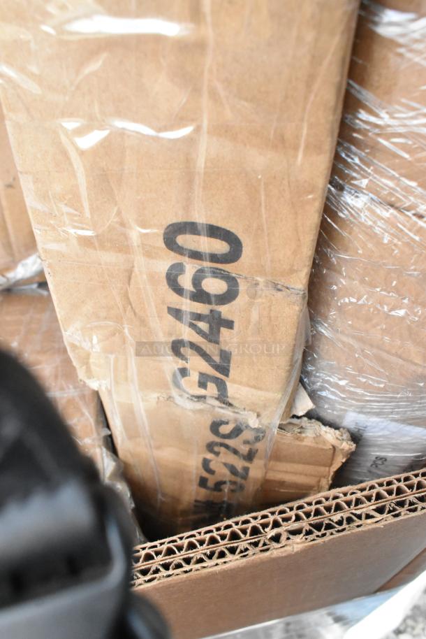 Cardboard boxes labeled "522SG2460" and wrapped in plastic, containing scratch and dent stainless steel tables.