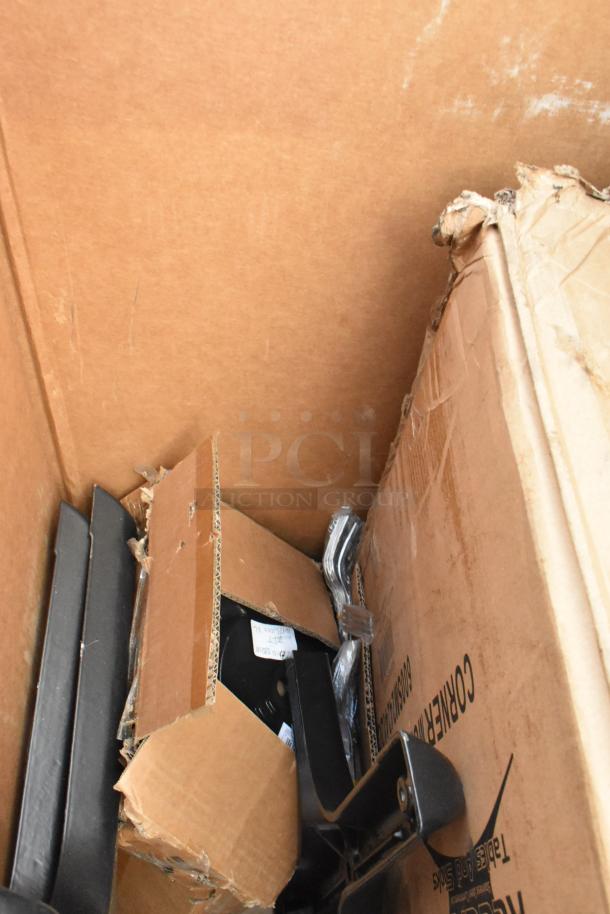 Nine new scratch and dent items in cardboard boxes, including Regency stainless steel ice bin and heavy-duty wall shelf.