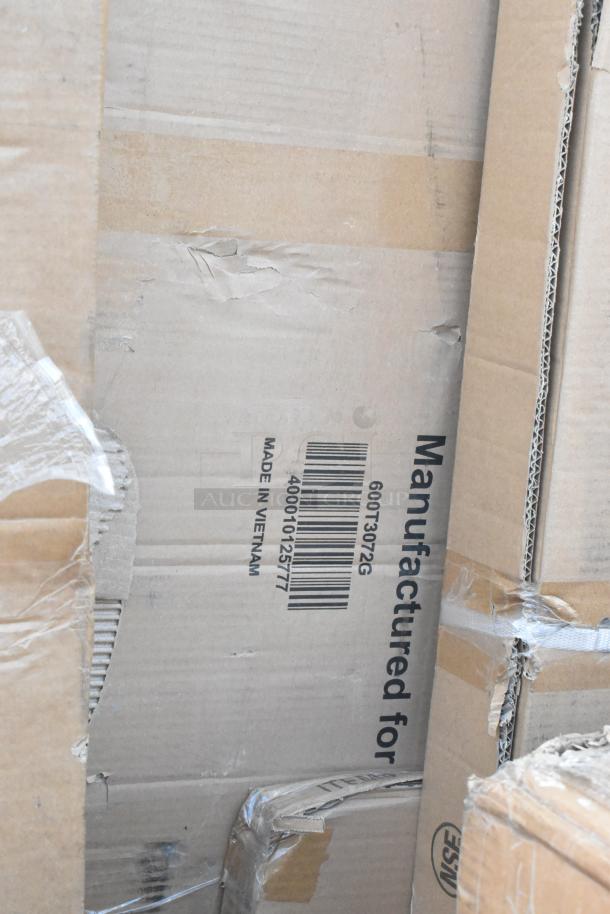 Damaged cardboard box with barcode and text "600T3072G, Made in Vietnam," indicating Regency commercial work table, new condition.