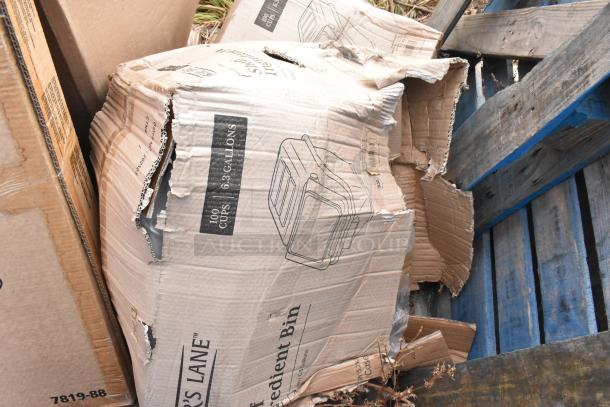 Torn cardboard box labeled "Baker's Lane 6.3 Gallon / 100 Cup Ingredient Bin" with sketch and text visible.