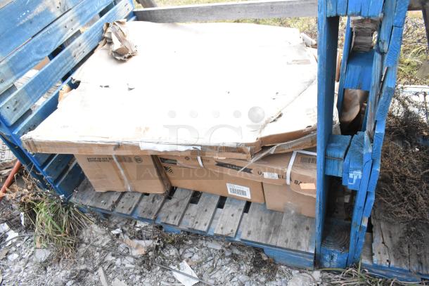 Five brand new scratch and dent items on a pallet, including Lancaster table and seating products with visible packaging.