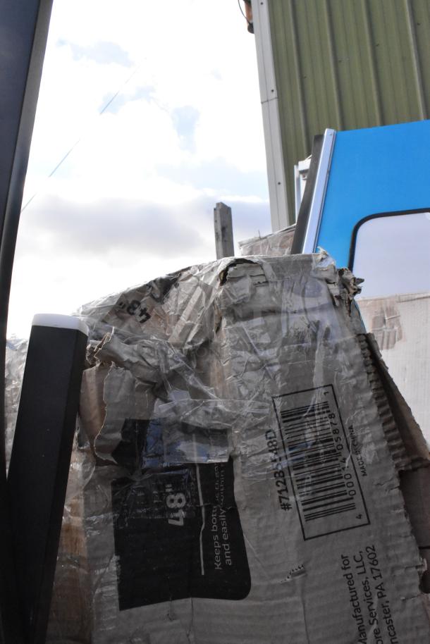 Damaged packaging containing various scratch and dent items, including a Steelton Stainless Steel Double Tier Speed Rail.