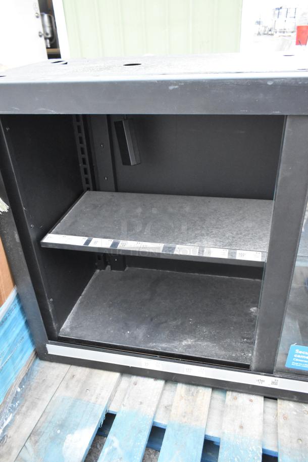 Metal 2 Door Dry Merchandising Cabinet, black, with shelves. Some surface wear. Ideal for retail displays.