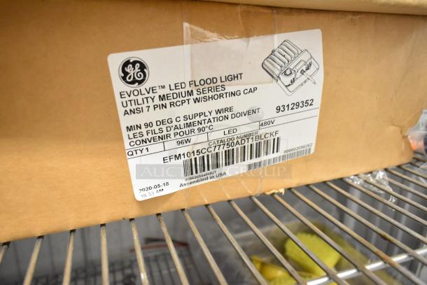 4 GE flood lights in packaging, models 93129352 and 1547328, 96W, 480V, new condition, includes label details.