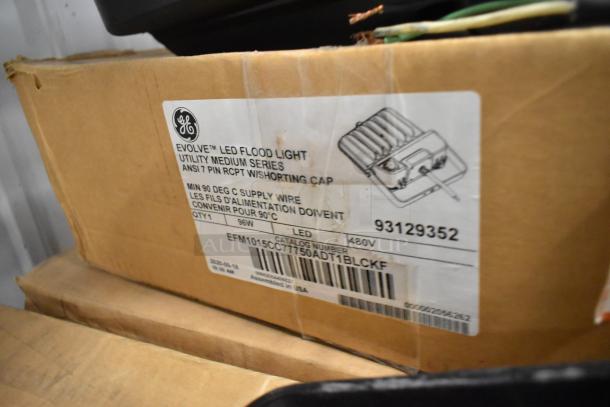 Box of GE Evolve LED Flood Lights, models 93129352 and 1547328, 96W, 480V. Includes product label with specifications.