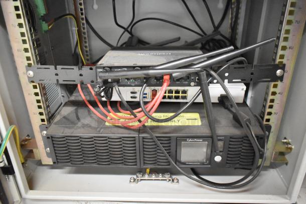 2 BlackShields DC0300 cabinets with Cradlepoint, CyberPower PR1000LCDRT2U UPS; white metal; air conditioned; visible cables.