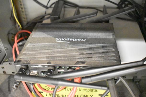 BlackShields DC0300 technology cabinet with Cradlepoint router, visible red cables, and CyberPower UPS unit inside.