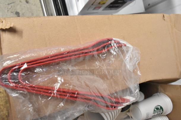 Cardboard box containing red tongs in plastic, stack of paper Starbucks cups; mixed lot in used condition.