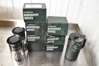 Starbucks Discovery Series mugs, 2 cold brew coffee makers, and a coffee press, new in boxes on display.