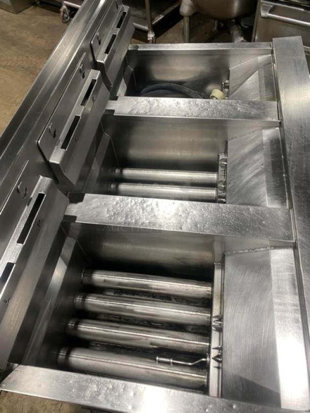 Henny Penny Evolution Elite model EEG-253 triple bay fryer system, stainless steel with backsplash, basket hanger, on casters.