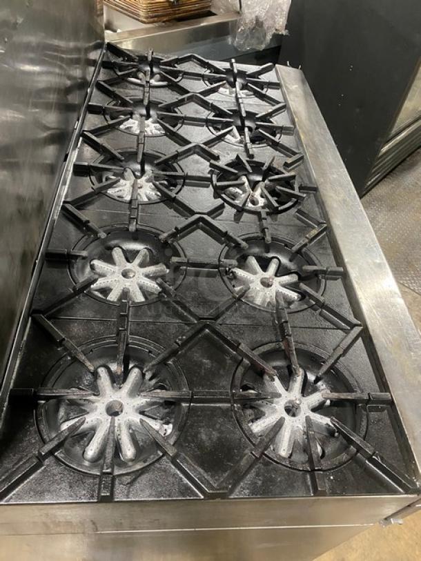 Garland stainless steel 10-burner gas range with double oven, backsplash, wired oven rack, and casters.