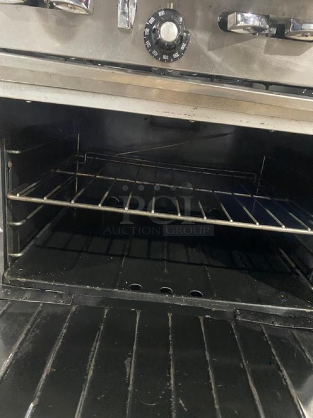 Garland commercial stainless steel gas 10-burner range/double oven combo with backsplash and wired oven rack, on casters.