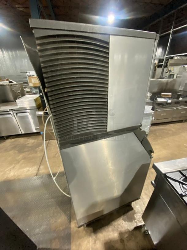 Manitowoc Indigo Series ice machine/bin combo in stainless steel; electric powered, on legs. Industrial setting, features visible.