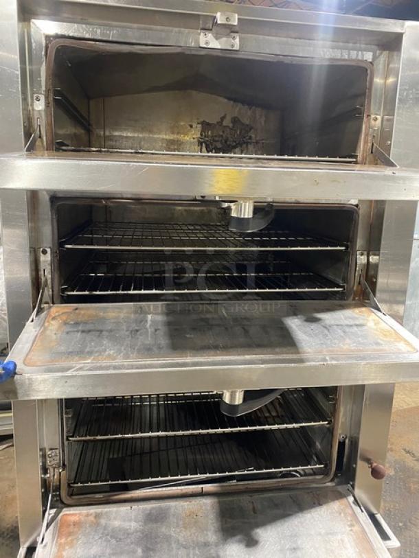 Commercial stainless steel 3-compartment seafood steamer with individual controls and wired oven rack, on legs. Used condition.
