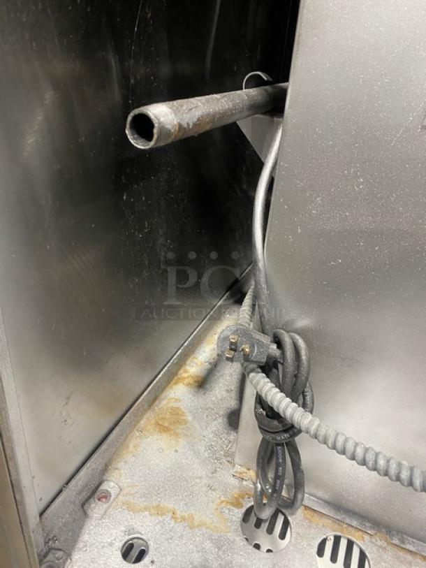 Industrial interior detail of Bakers Pride CO11G1 convection oven showing metal casing, cords, and piping.