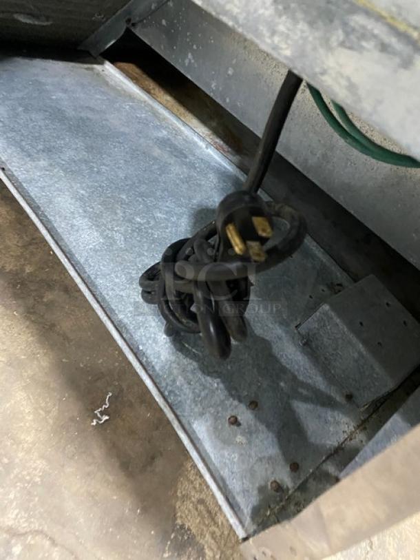 Delfield stainless steel refrigerated prep table cord, part of Model D4448N-18M, 115V, coiled on a metallic surface.