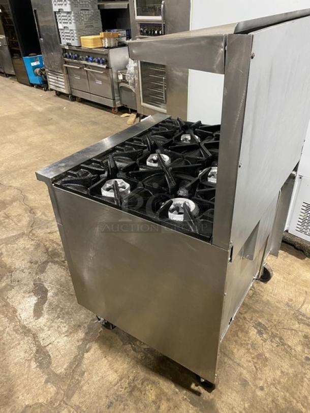 SunFire stainless steel 6-burner gas range/oven combo with backsplash, salamander shelf, and wired rack, on casters.