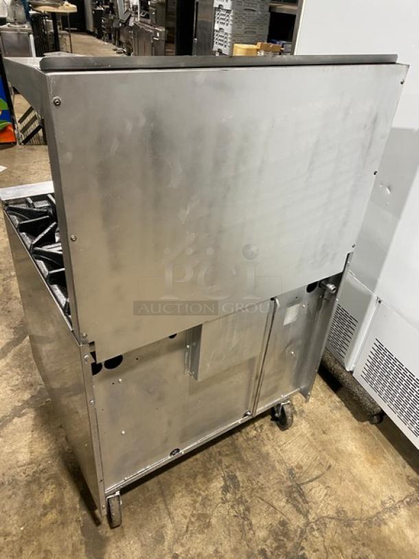 SunFire commercial stainless steel 6-burner range/oven combo with back splash, overhead salamander shelf, and wired oven rack. Mounted on casters.