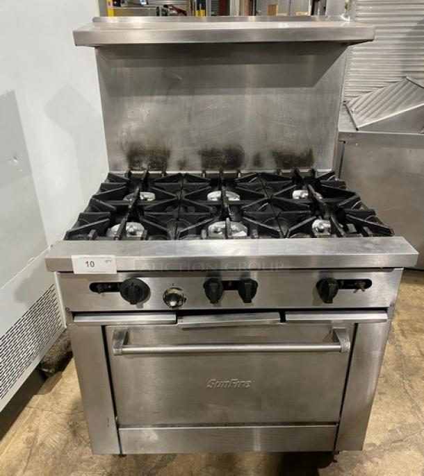 SunFire stainless steel 6-burner range/oven combo with back splash, overhead salamander shelf, and wired oven rack on casters.