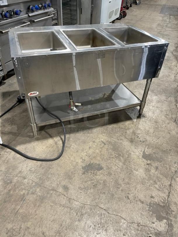 Eagle Group stainless steel electric 3-well hot food steam table with tray slide, undershelf, and legs.