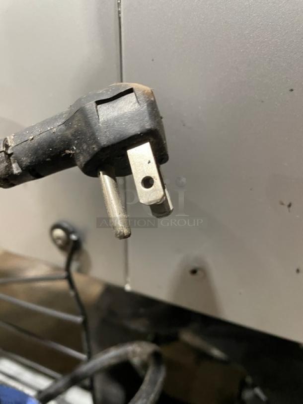 Power cord of Fogel Commercial Freezer Model CR-49-SDF, 115V, 1 Phase, on casters. Plug shows wear, indicating use.