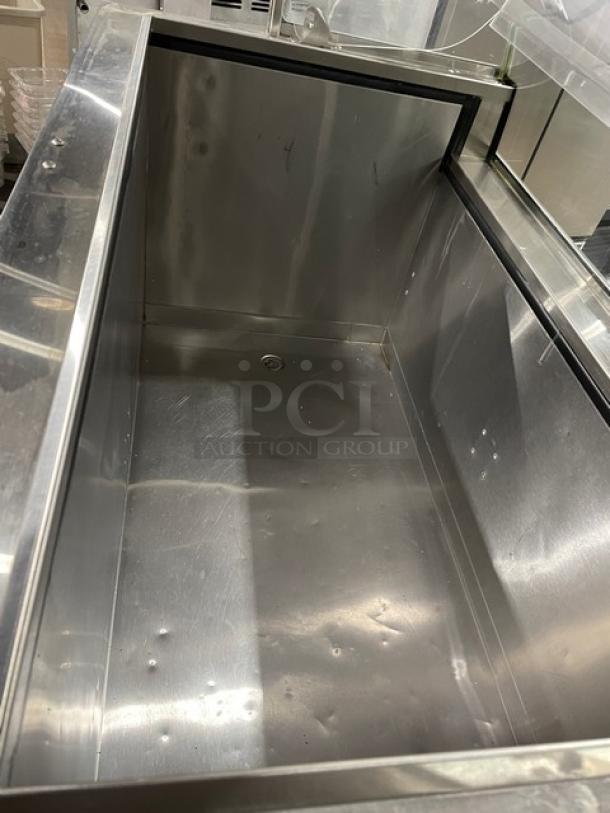 Commercial white curved glass ice cream dipping cabinet with rear lift-open access, SN: N1902303, stainless interior.