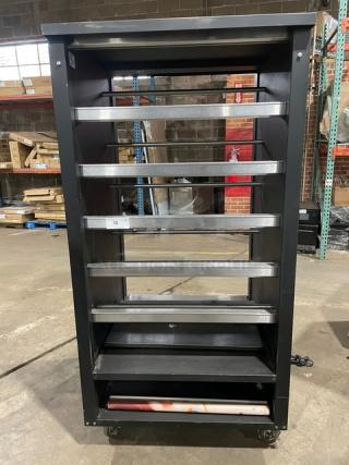 Vulcan Model 1013776 5-tier lighted bakery display case with stainless steel interior and enclosed storage, on casters.