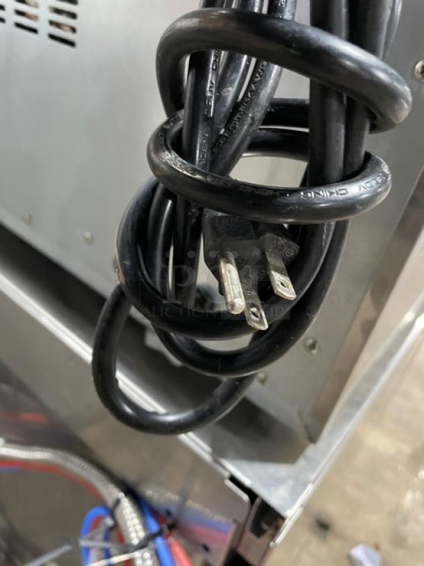 Kitma KMCC50 stainless steel convection oven power cord, 120V. Close-up shows standard 3-prong plug. Model: KMCC50.