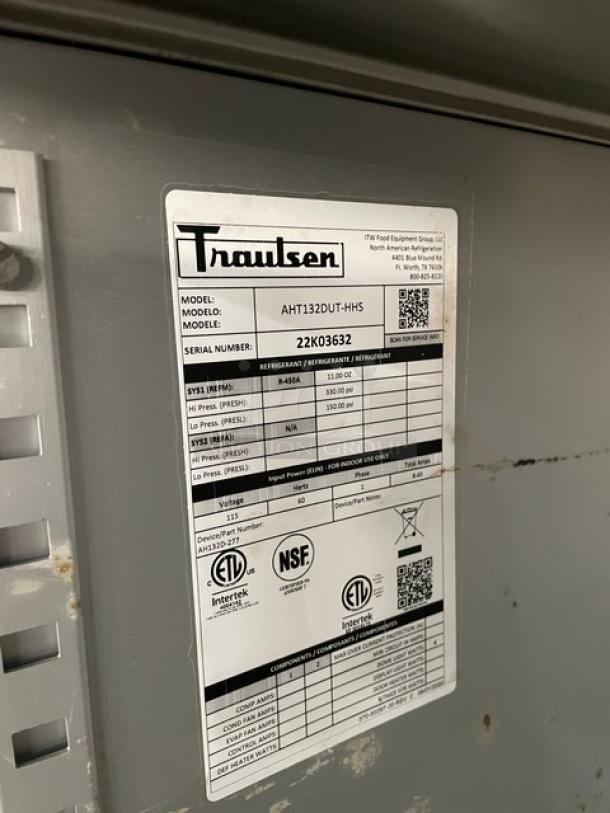 Traulsen model AHT132DUTHHS label with serial number 22K03632, electrical specs, and certifications on stainless steel surface.