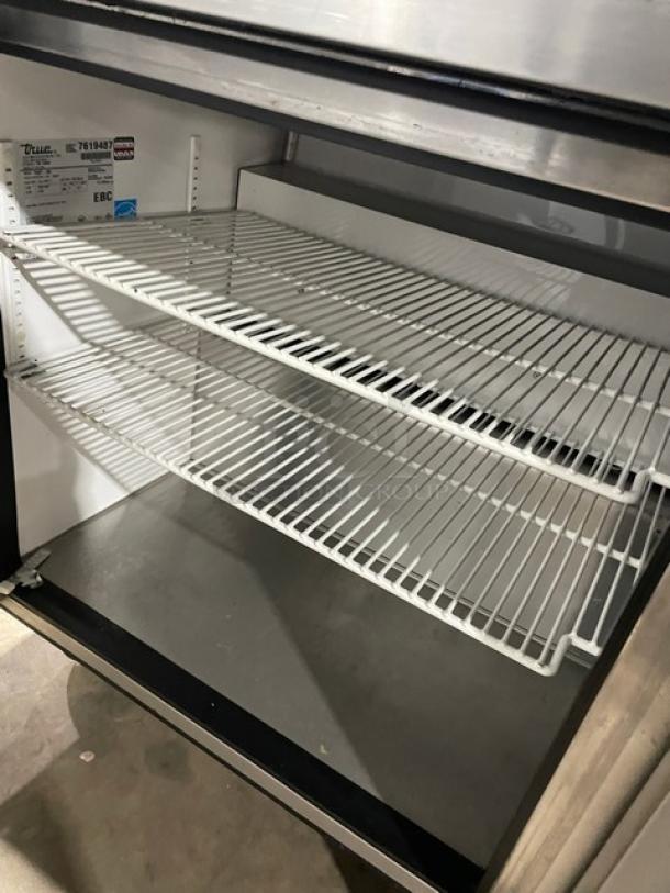 True TWT-60 stainless steel 2-door worktop refrigerator with backsplash, poly-coated wire rack, Energy Star certified, on casters.