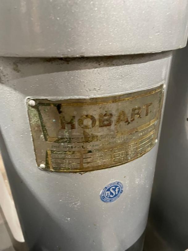 Hobart VCM40 commercial mixer with stainless steel tilting bowl. Features identification plate and NSf label visible.