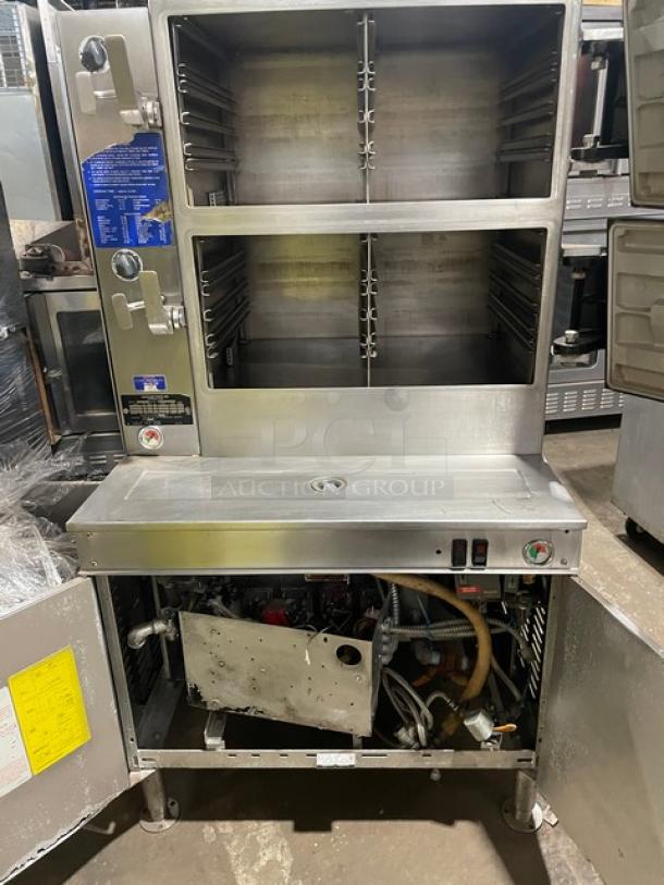 Cleveland Range commercial stainless steel 2-compartment pressure steamer with individual controls, built-in pan slides, and enclosed cabinet base.