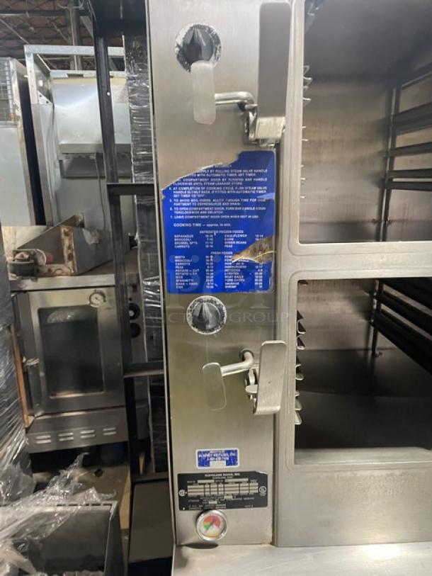 Cleveland Range stainless steel 2-compartment pressure steamer with individual controls, pan slides, enclosed cabinet base, on legs.