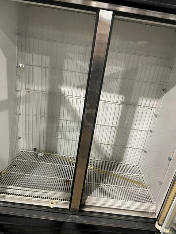 True GDM-49F black reach-in freezer with double glass swing doors, poly coated wire rack, model and serial numbers visible.