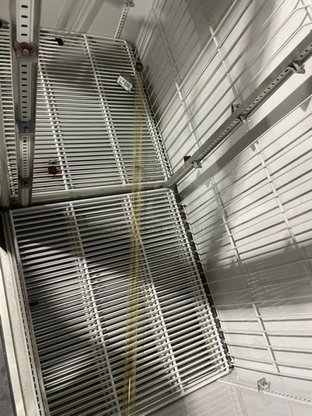 True GDM-49F commercial freezer interior with poly-coated wired racks, showing ample storage space. Model label visible.