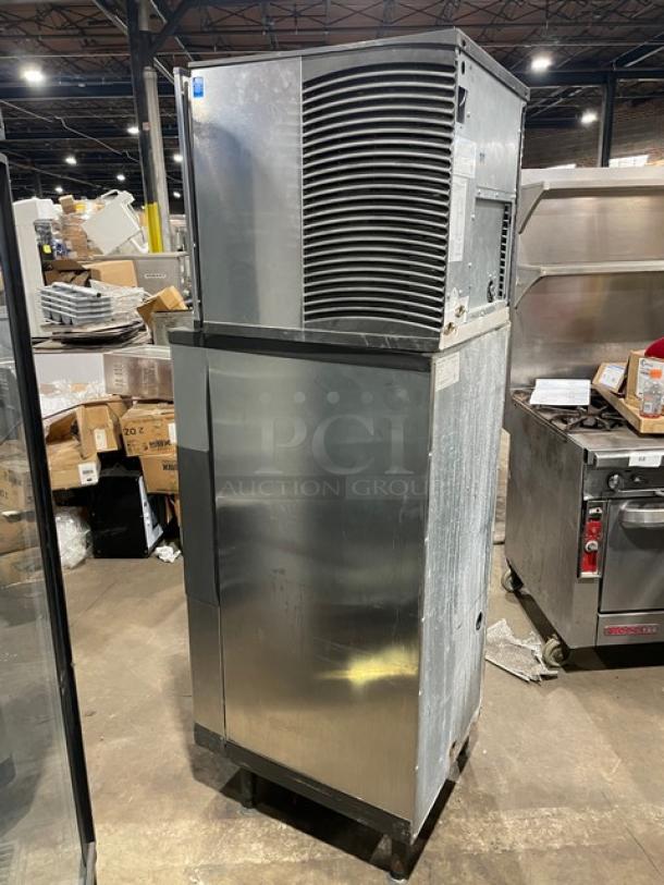 Manitowoc stainless steel ice machine with water-cooled head and storage bin, model SD0423W/QPA160, on legs, in a warehouse.